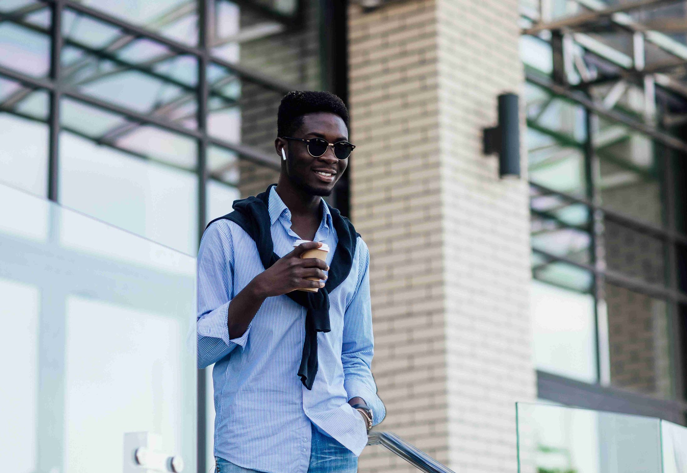 people-technology-lifestyle-happy-young-man-with-headphones-smartphone-listening-music-city-with-cup-coffe
