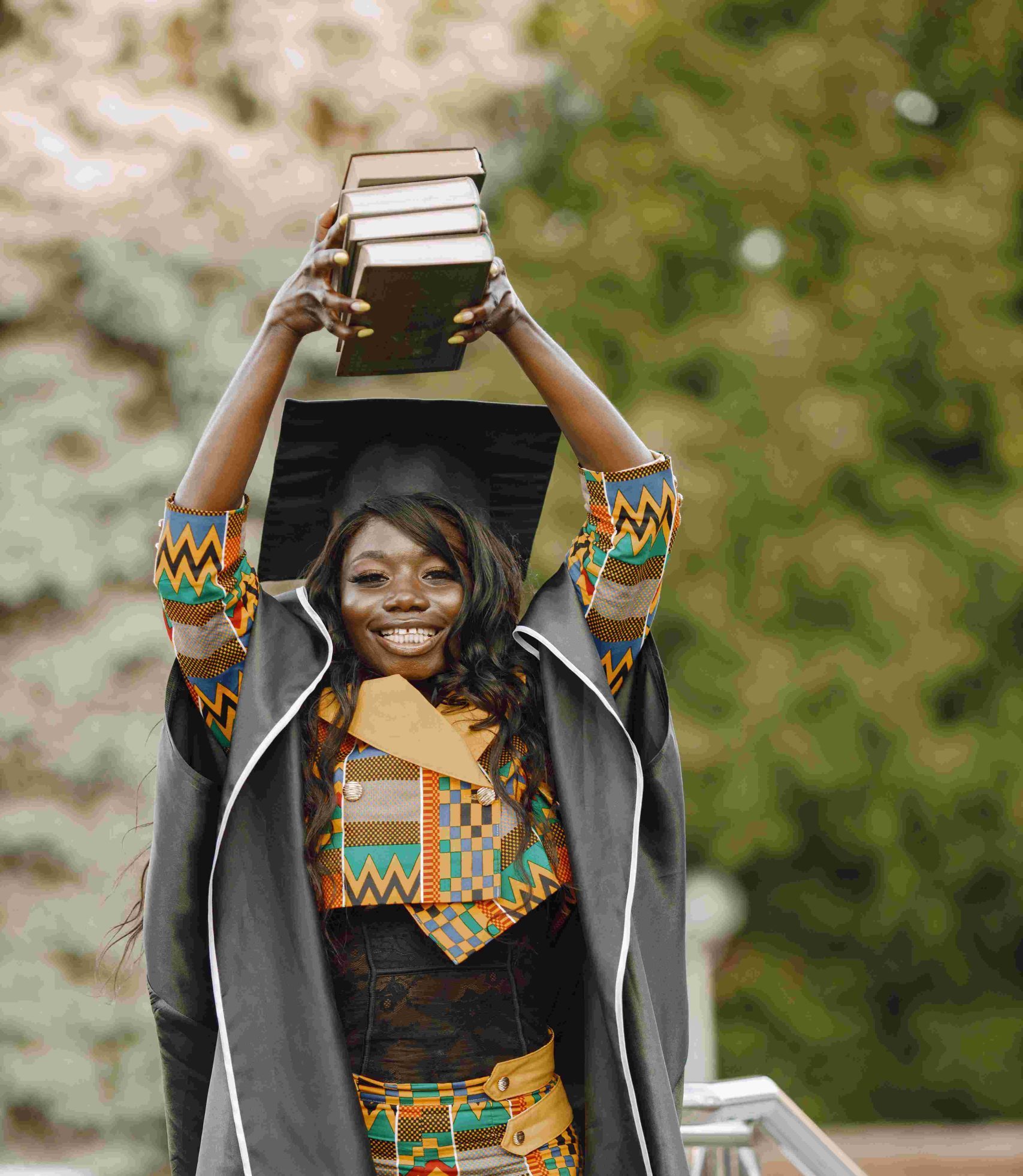 young-afro-american-female-student-dressed-black-graduation-gown-campus-as-background